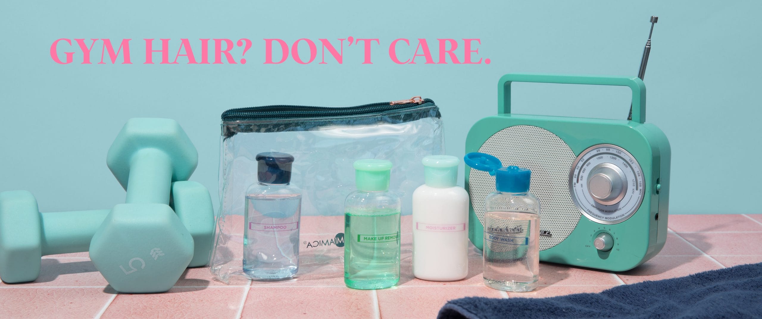 Image of clear Travel Bottle Set zippered pouch and Miamica blue flip-top bottles for body care & skin care items. Surrounded by teal 5lb gym weights and a mini radio.